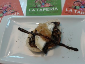 Tosta de setas y rulo de cabra con cebolla caramelizada y reducción de vino dulce.